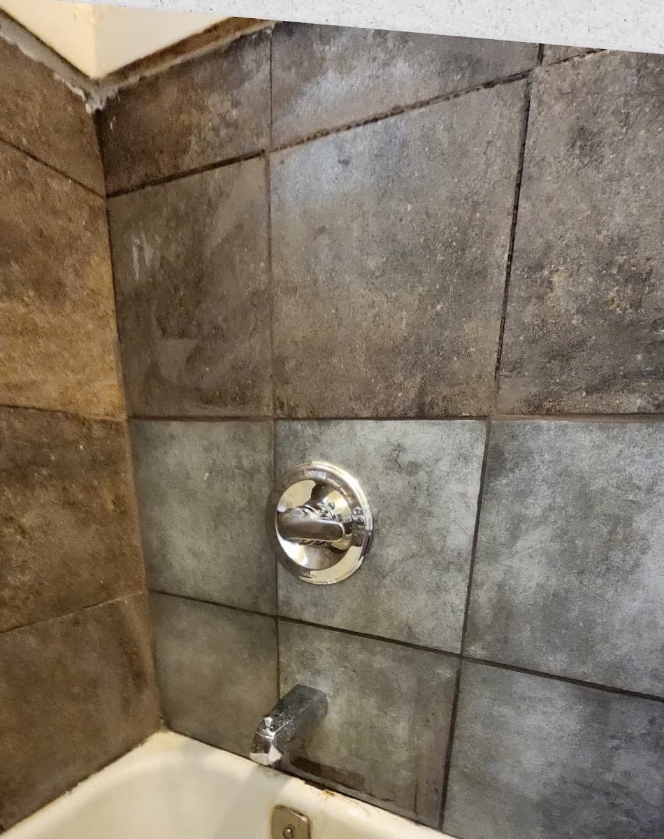 The same shower wall closed back in with the tile re-set around the new valve trim by Drywall & Remodeling ETC.