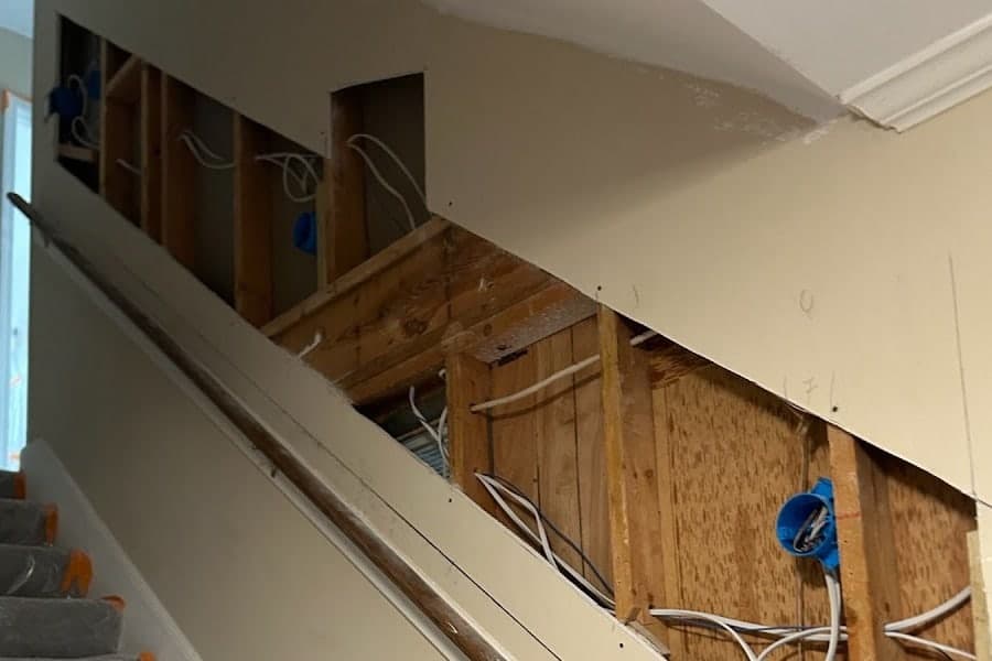 Stairwell wall opened down to the studs and wiring before drywall installation by Drywall & Remodeling ETC. in Memphis, TN